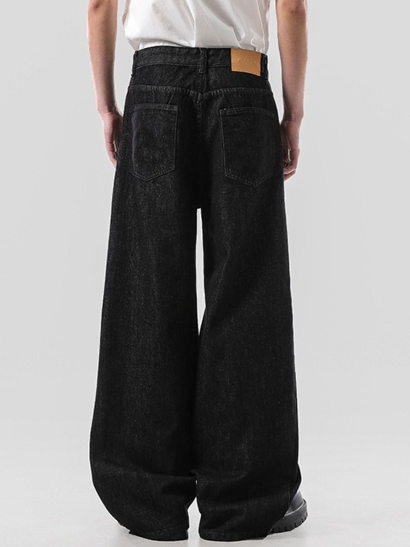 Back view of the URBAN UNIT Nova Wide-Leg Denim, showcasing the classic pocket structure, leather patch detail, and relaxed streetwear fit.