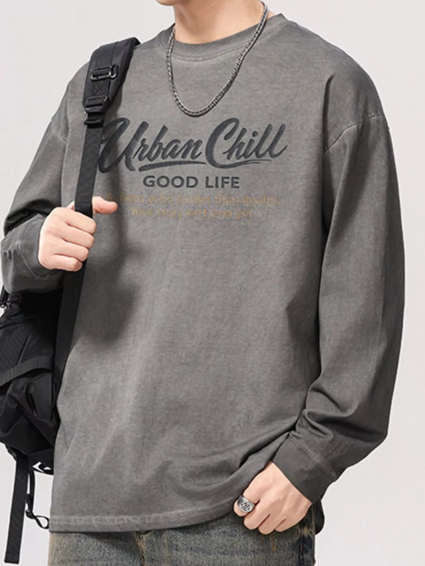 URBAN UNIT ECHO Oversized Long Sleeve in Concrete Grey - Lifestyle Shot with Backpack and Graphic Close Up