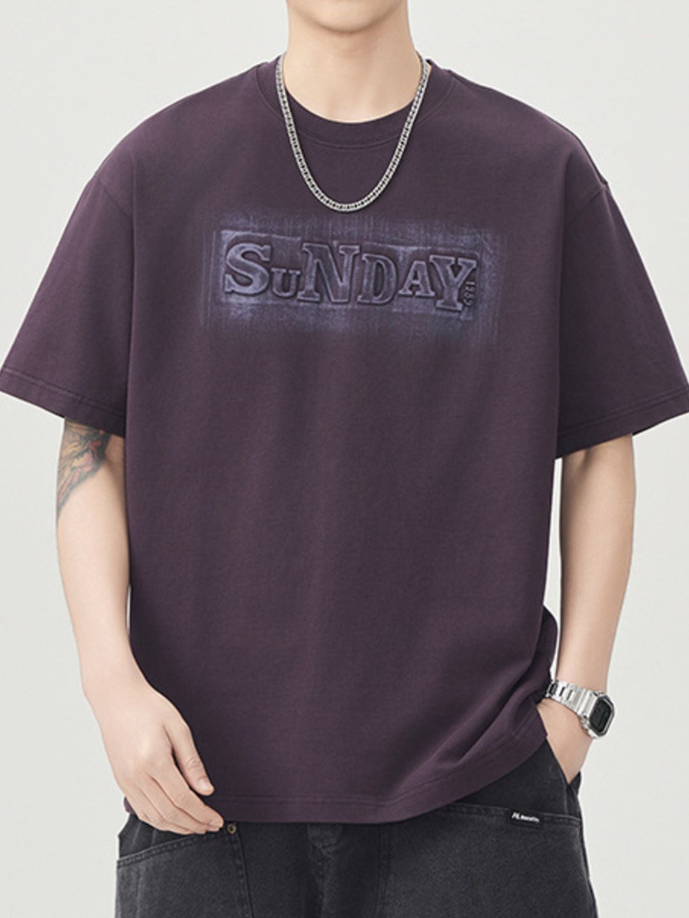Front view of the URBAN UNIT SUNDAY Origin Oversized Tee in Faded Plum, featuring a tonal embossed Sunday chest graphic and drop-shoulder fit.