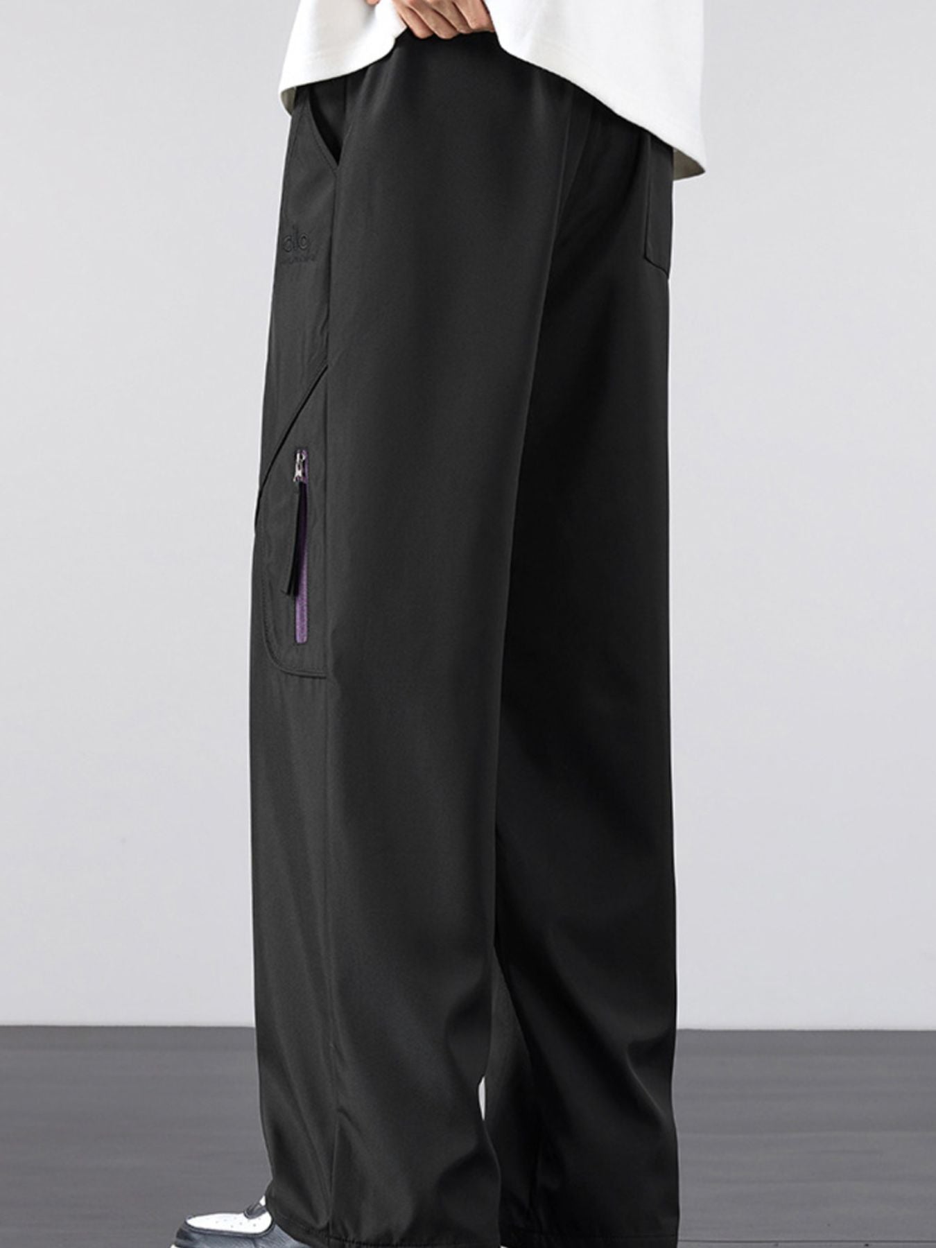 Side profile and deep pocket detail of the UU Vector Zip Loose-Fit Cargo Pants in Midnight Black by URBAN UNIT.
