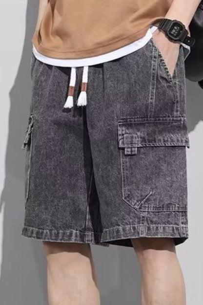 Model wearing URBAN UNIT Vintage Wash Cargo Denim Shorts in Faded Obsidian. Showing the oversized urban fit, deep side cargo pockets, and adjustable drawstring.