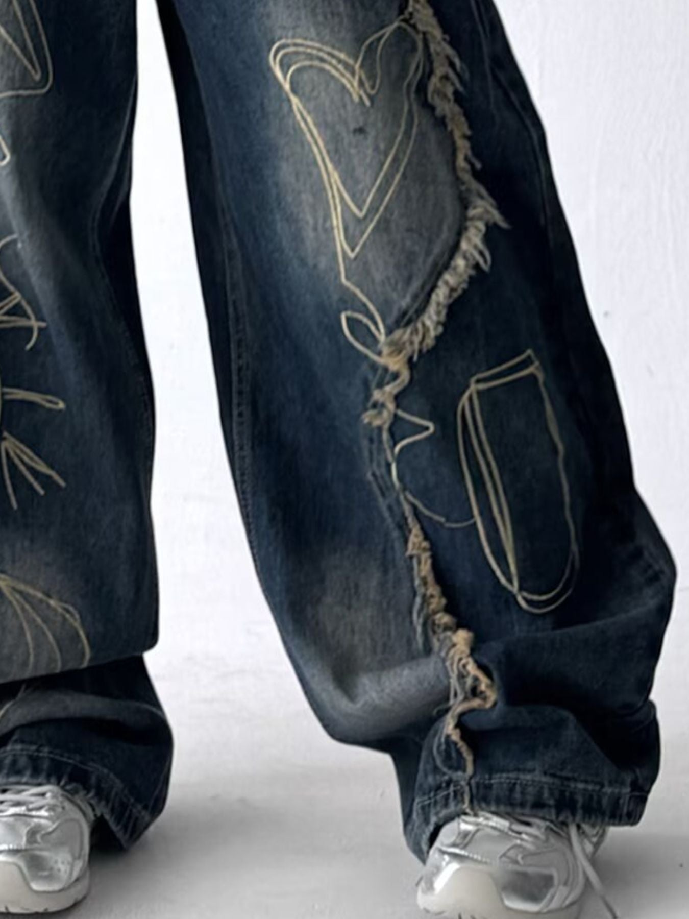 Close up of the ultra-wide leg drape and raw frayed seams on URBAN UNIT oversized streetwear jeans.