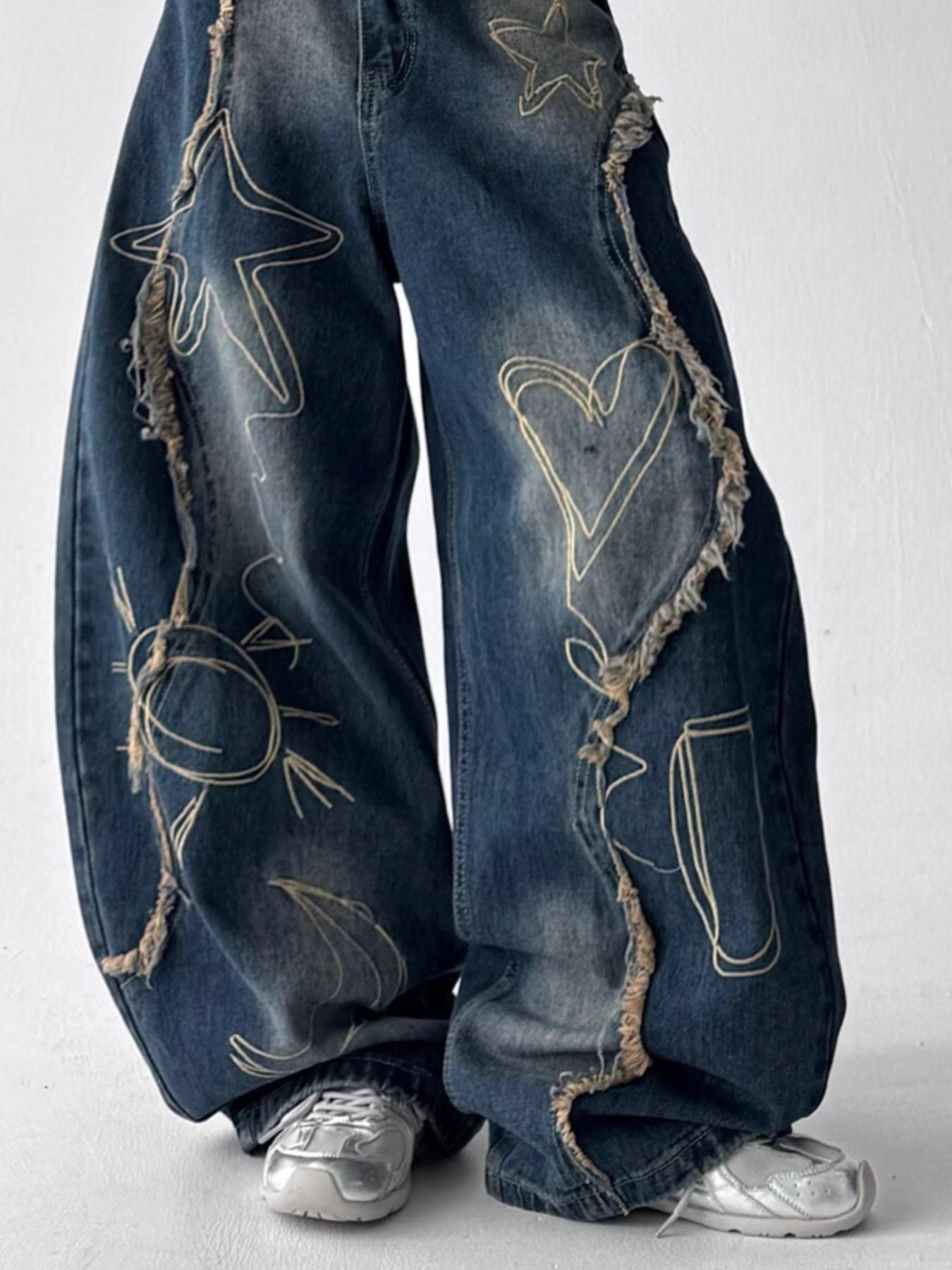 Front view of URBAN UNIT wide-leg denim with deconstructed frayed star and heart seam detailing in vintage indigo.
