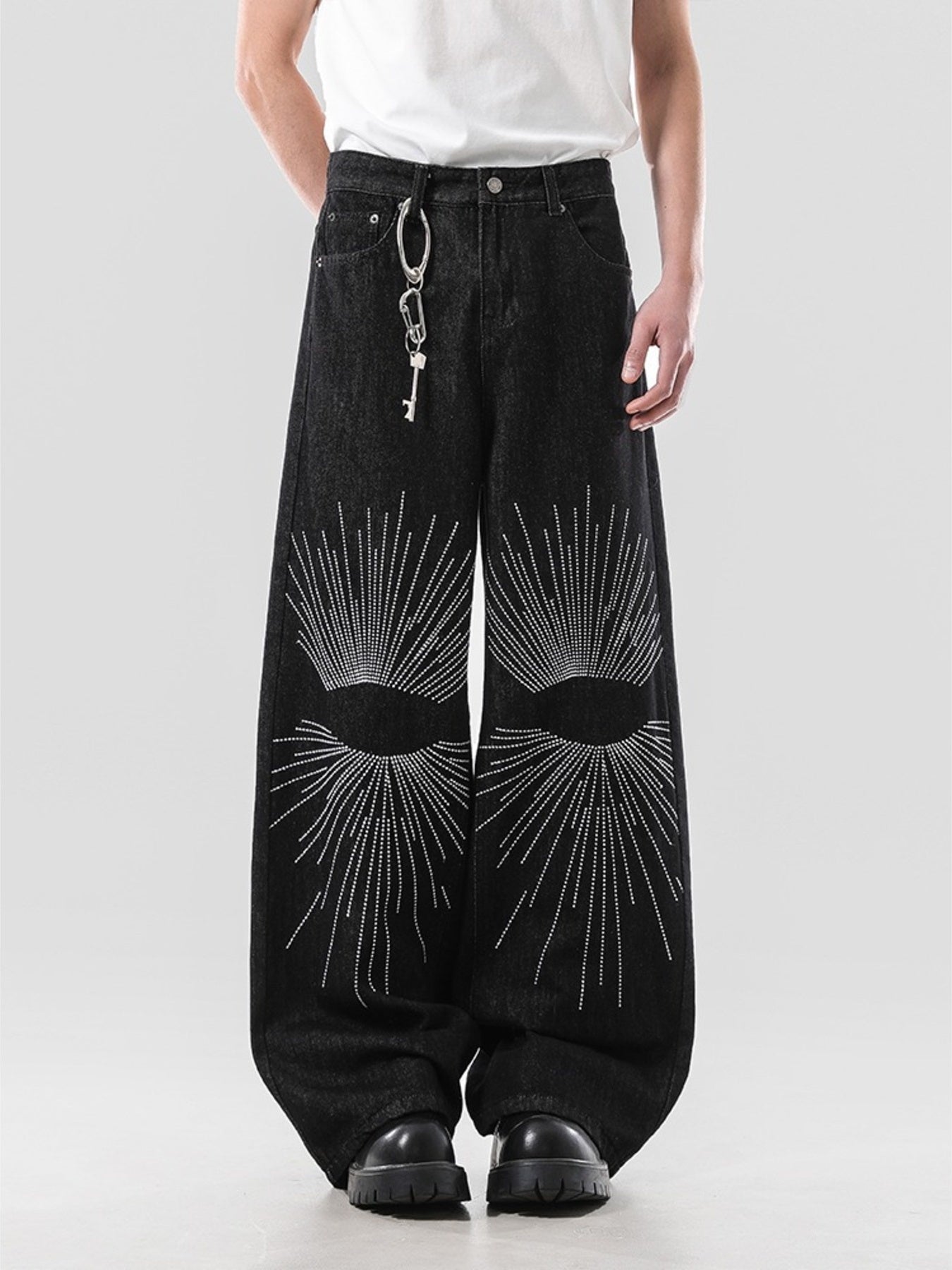 Model wearing the URBAN UNIT Nova Wide-Leg Denim in washed black, featuring a heavy oversized drape and striking white sunburst knee embroidery.