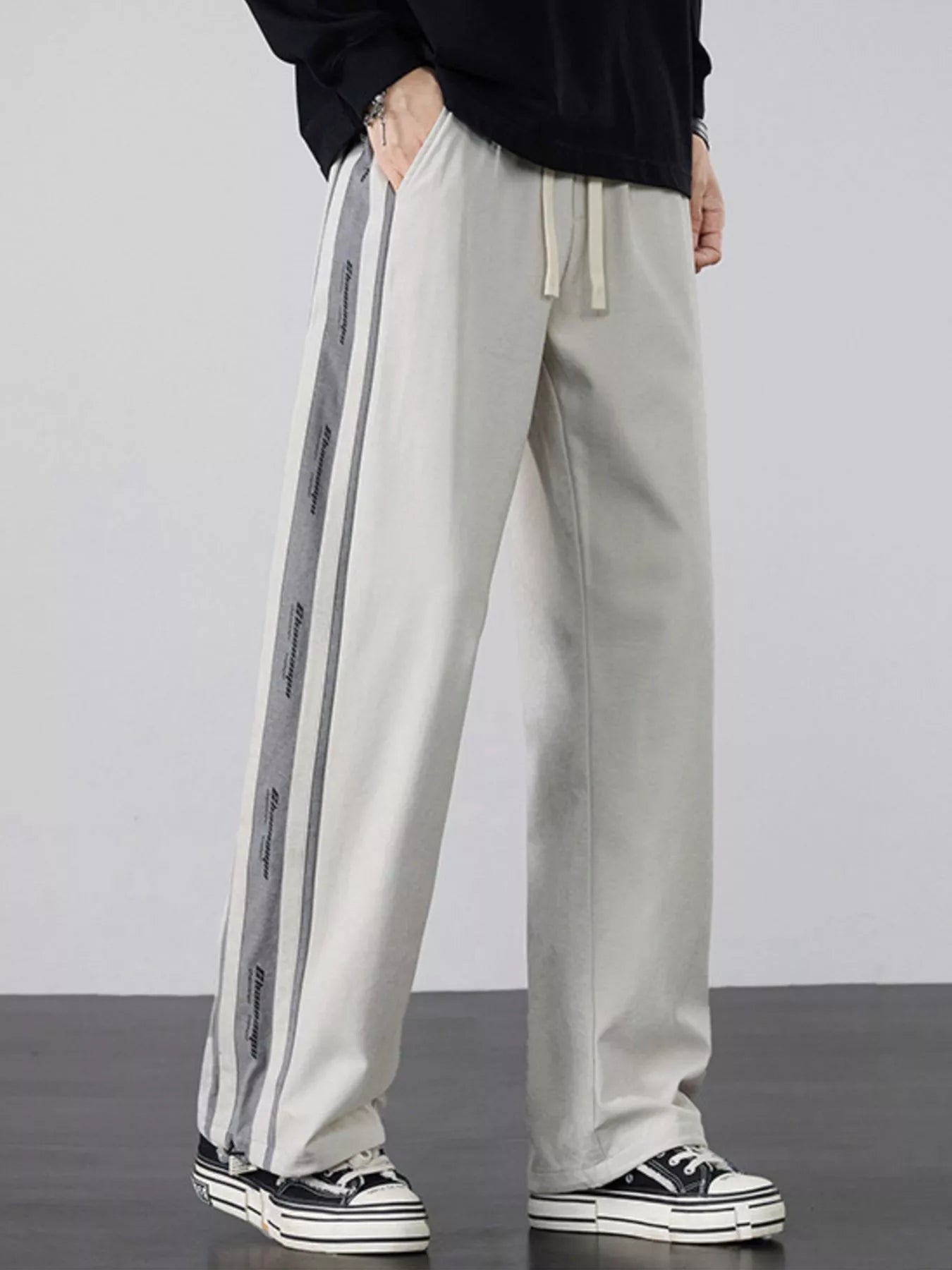Industrial Beige wide-leg pants highlighting the tactical side stripes.