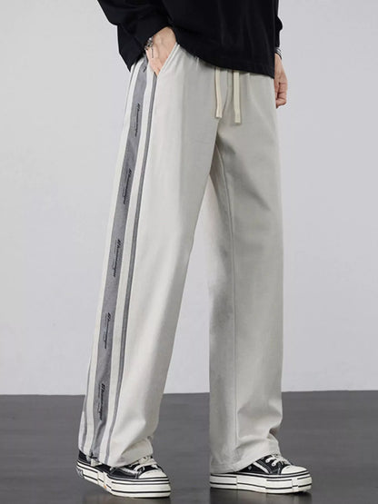 Industrial Beige wide-leg pants highlighting the tactical side stripes.