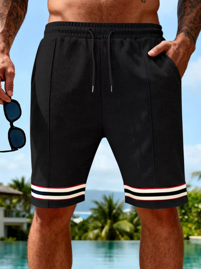 URBAN UNIT Sector Silhouette Textured Knit Shorts in Midnight Black. Essential men's oversized streetwear shorts with a bold contrast striped hem and adjustable drawstring waist.